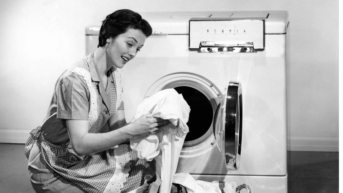 Eine Hausfrau vor einer Waschmaschine aus den 50er Jahren