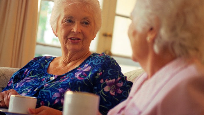 Zwei ältere Damen sitzen bei einem Kaffee zusammen