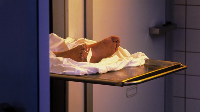 Teilansicht einer Leiche im Leichenschauhaus mit einem Schild an der Zehe.