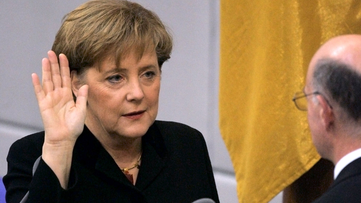 Kanzlerin Merkel steht vor Bundestagspräsident Lammert und hebt die Hand zum Schwur | Bildquelle: dpa/Peer Grimm Kanzlerin Merkel steht vor Bundestagspräsident Lammert und hebt die Hand zum Schwur