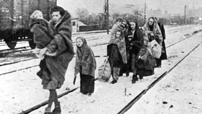 Polnische Frauen flüchten im Jahr 1945 mit ihre Kindern. Das schwarz-weiß Foto zeigt sie auf einem Bahnhof.