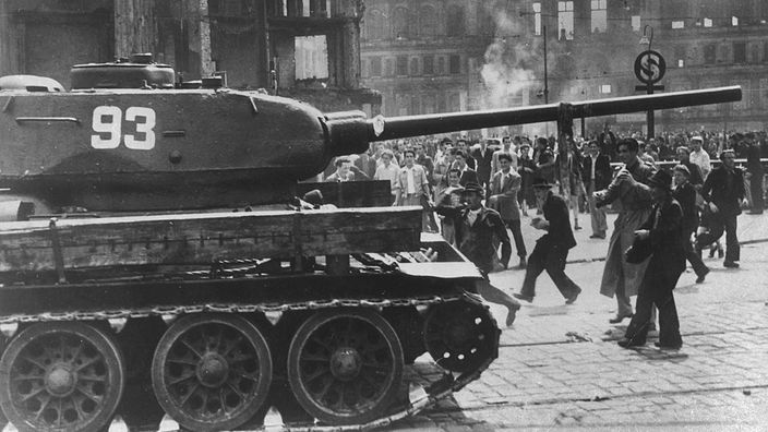 Schwarzweiß-Foto eines Panzers, der einer Menschenmenge gegenübersteht.