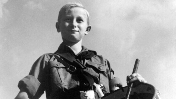 Ein Kind aus der Hitler Jugend trommelt.