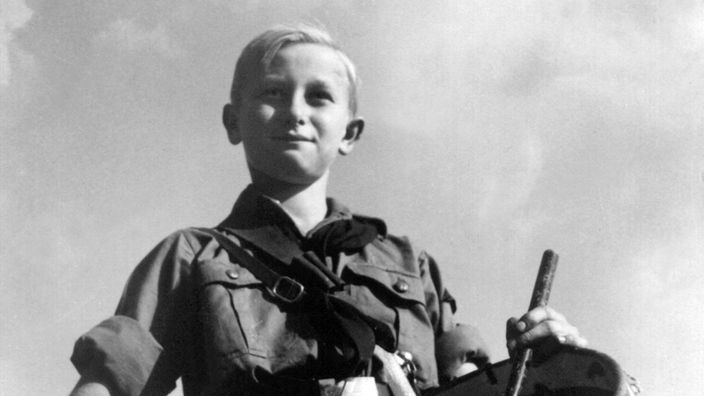 Ein in Uniform gekleideter Junge, Mitglied der nationalsozialistischen Hitlerjugend, beim Schlagen seiner Trommel.