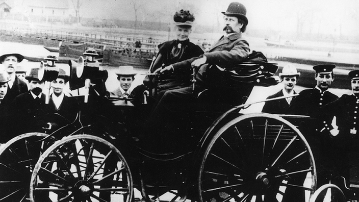 Karl Benz mit Gattin Berta am Steuer seines Kraftwagens | Bildquelle: akg-images Karl Benz mit Gattin Berta am Steuer seines Kraftwagens