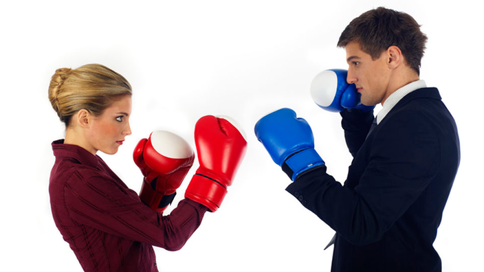 Mann und Frau stehen sich mit Boxhandschuhen gegenüber.