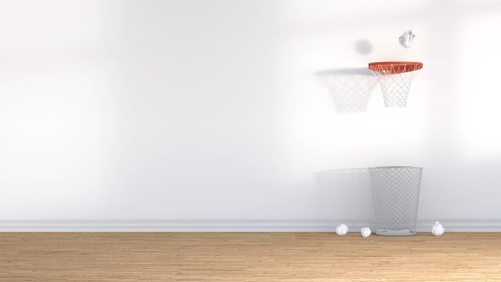 Ein Basketballkorb hängt über einem Papierkorb