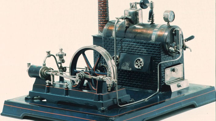 Eine Dampfmaschine mit Kamin und Räderwerk aus dem Jahr 1912.