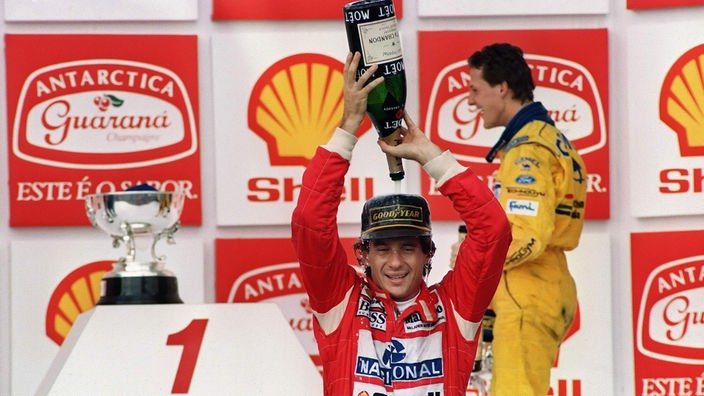 Ayrton Senna gießt sich eine Sektflasche über den Kopf. Im Hintergrund Michael Schumacher