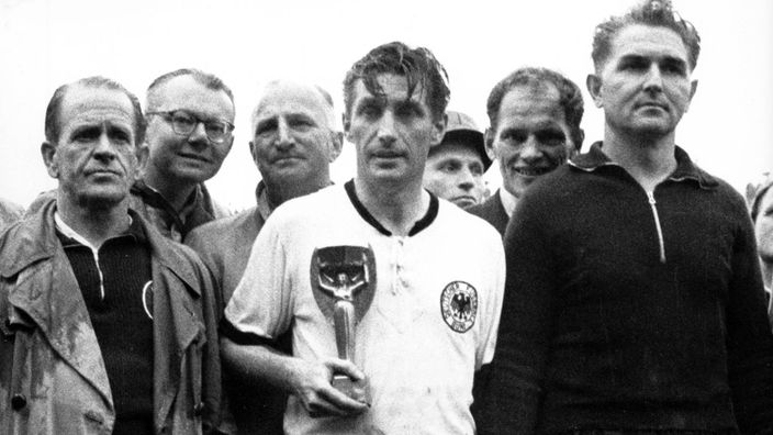 Fritz Walter mit WM-Pokal, daneben Sepp Herberger und Toni Turek