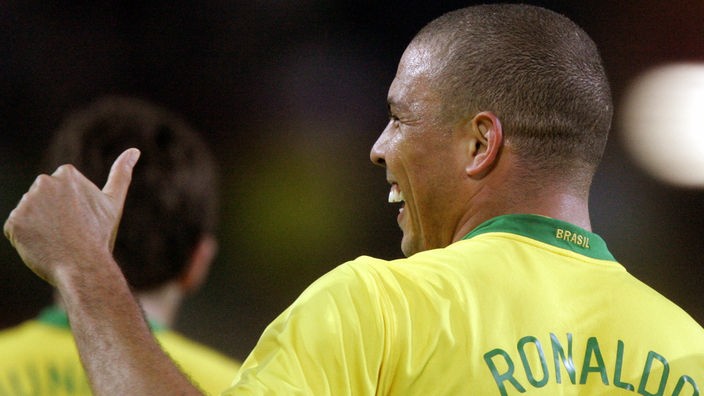 Seitliche Aufnahme auf den lachenden Ronaldo. Er streckt den linken Daumen in die Luft.