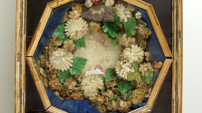 Holzkasten enthält eine Blumenkrone | Bildquelle: WDR/dpa Holzkasten enthält eine Blumenkrone