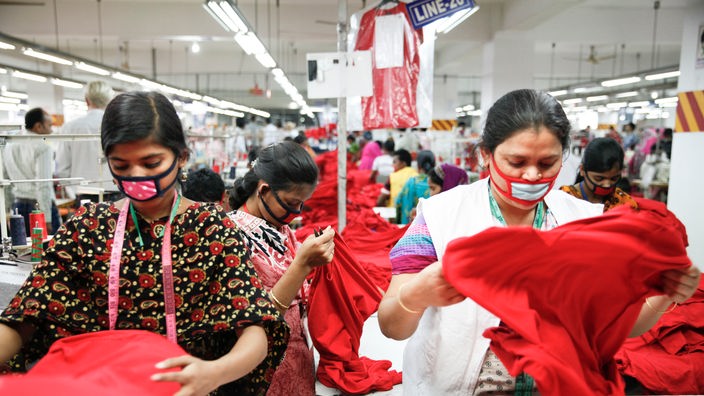 Arbeiterinnen mit Mundschutz in einer Textilfabrik in Bangladesch