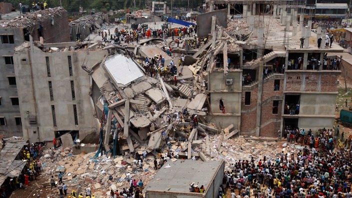 Viele Menschen sind um die eingestürzte Textilfabrik Rana Plaza versammelt, Archivbild