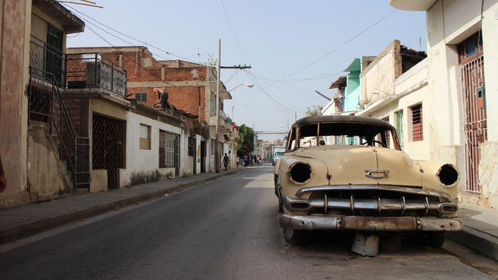 Ein verlassenes, rostiges altes Auto auf einer Straße