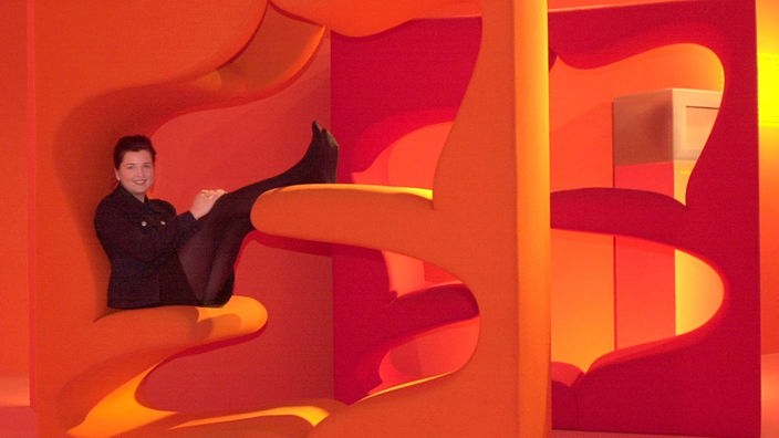 Frau macht es sich in einem von zwei "Living Towers" (1968) des dänischen Designers Verner Panton gemütlich