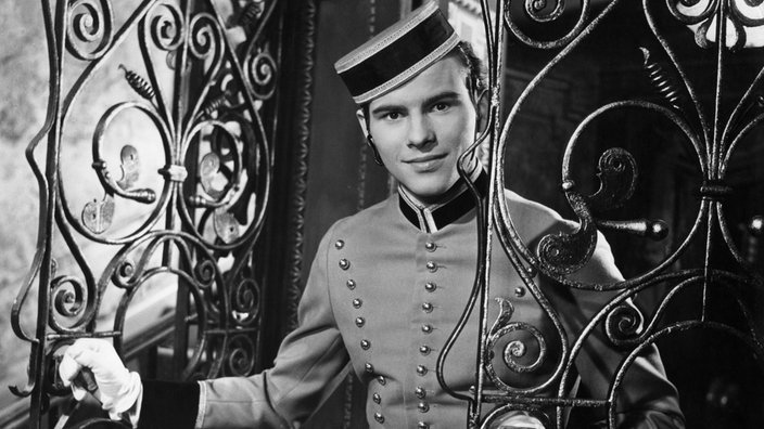 Horst Buchholz als Felix Krull in Liftboyuniform im Film "Die Bekenntnisse des Hochstaplers Felix Krull". | Bildquelle: WDR / INTERFOTO / LINUS Horst Buchholz als Felix Krull in Liftboyuniform im Film "Die Bekenntnisse des Hochstaplers Felix Krull".