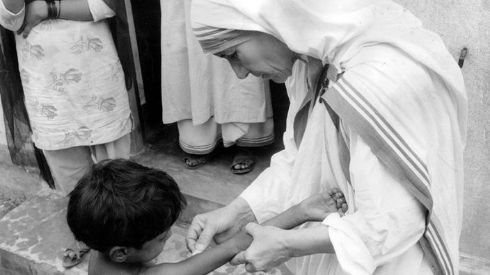 Schwarzweiß-Bild: Mutter Teresa impft ein Kind