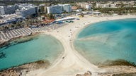Luftaufnahme des Strandes Nissi Beach mit zwei Strandabschnitten und Hotelkomplexen