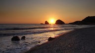 Sonnenuntergang am Strand bei einem Felsen, der als Felsen der Aphrodite bekannt ist