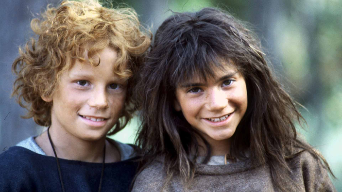 Zwei junge Schauspieler, die als Räuberkinder Ronja und Birk verkleidet sind, grinsen den Betrachter an.