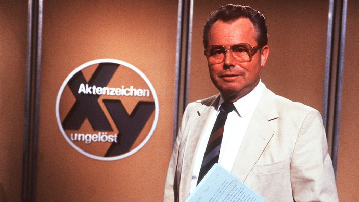 Eduard Zimmermann vor dem Logo "Aktenzeichen XY"