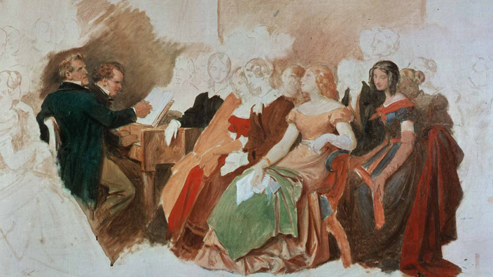 Eine Ölskizze zeigt den Komponisten Schubert und den Sänger Michael Vogl am Klavier. Umringt werden sie von Damen in edler Gaderobe.