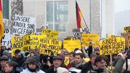 Demonstranten vor dem Kanzleramt mit Schildern
