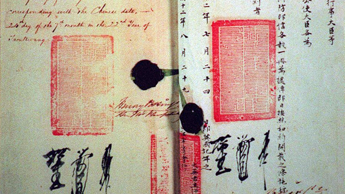 Originalvertrag von 1842: Auf der linken Seite sind nicht leserliche englische Worte zu sehen, auf der rechten Seite chinesische Zeichen. Auf beiden Seiten jeweils ein roter Stempel.