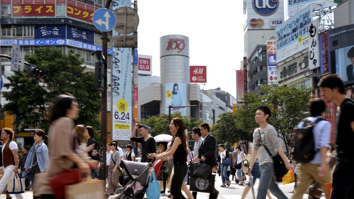Fußgänger gehen im Stadtteil Shibuya über die Straße. | Bildquelle: AFP/YOSHIKAZU TSUNO Fußgänger gehen im Stadtteil Shibuya über die Straße.