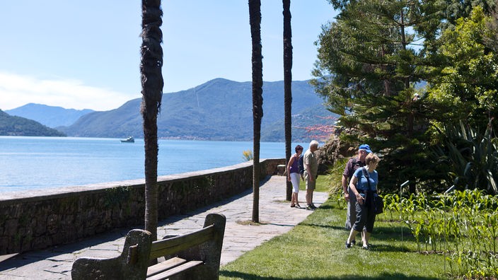 Touristen betrachten subtropische Pflanzen auf den Brissago-Inseln im Lago Maggiore im Kanton Tessin.