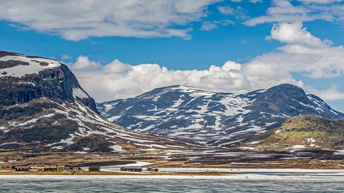 Häuser am Fuß von verschneiten Bergen in Norwegen