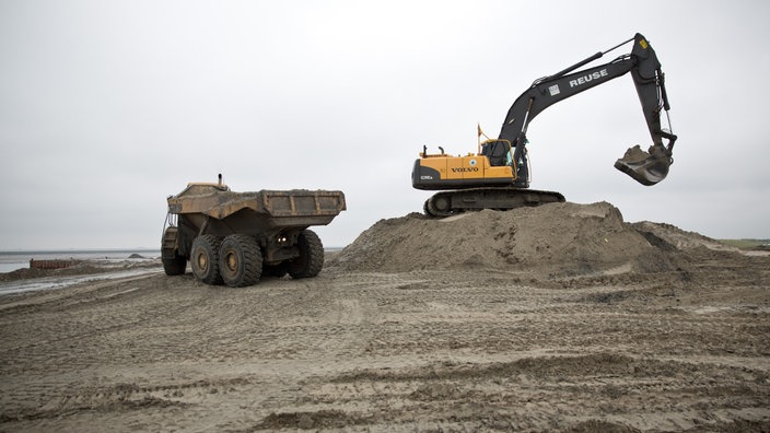 Ein Bagger und ein Kipplader auf einer Deichbaustelle 