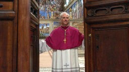 Ein Kardinal schließt große Holztüren zur Sixtinischen Kapelle.