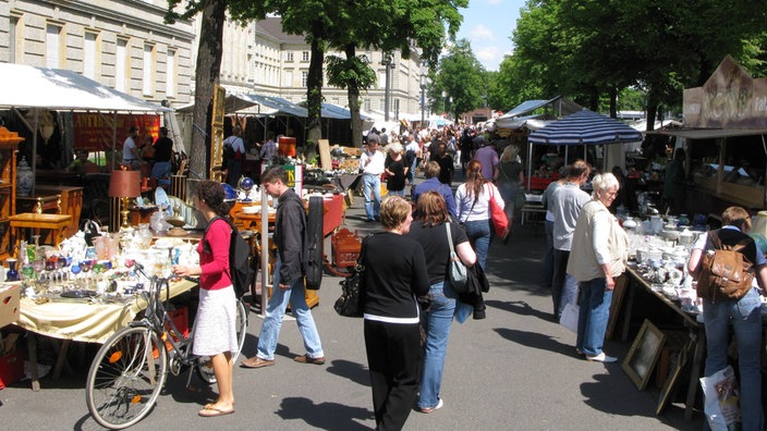 Passanten bummeln an einem Sommertag über einen Flohmarkt und begutachten die Stände | Bildquelle: IMAGO/F. Berger Passanten bummeln an einem Sommertag über einen Flohmarkt und begutachten die Stände