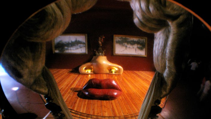 Innenaufnahme aus Dalís Teatre-Museum im spanischen Figueres. Das Foto zeigt eine abstrakte Installation, die ein Gesicht darstellt. 