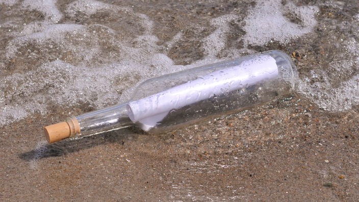 Eine Flaschenpost an einem Strand.