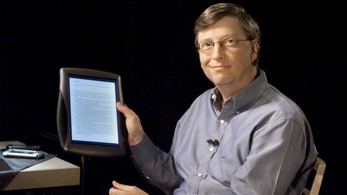Bill Gates hält einen Tablet-PC in der Hand.