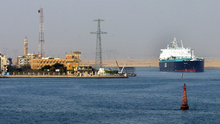 Ein Tankschiff verlässt den Suezkanal. Links ist die Stadt Suez zu sehen