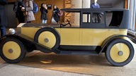 Holzsarg in Form eines alten Daimlers.