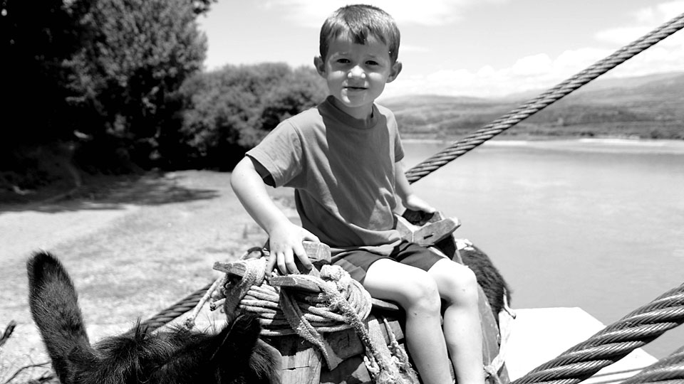 kleiner Junge auf einem Esel, Schwarzweiß-Aufnahme