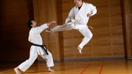 Ein Karate-Kämpfer tritt im Sprung