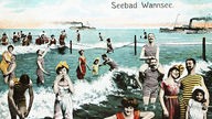 Koloriertes Foto von vielen Badegästen, die im Wasser stehen. Dahinter fahren Schiffe, oben stehen die Wörter 'Seebad Wannsee'.