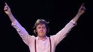 Paul McCartney mit ausgebreiteten Armen auf der Bühne