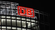 Das Logo der Deutschen Bahn scheint des Nächtens vom Firmensitz in Berlin