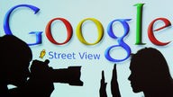 Schattenspiel eines Fotografen mit seinem Model vor einem beleuteten Google Streetview Schriftzug