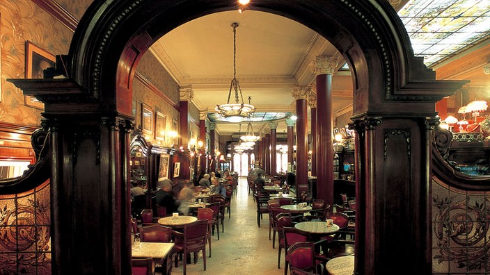 Innenansicht des voll besetzten Café Tortoni mit seiner traditionellen Inneneinrichtung.