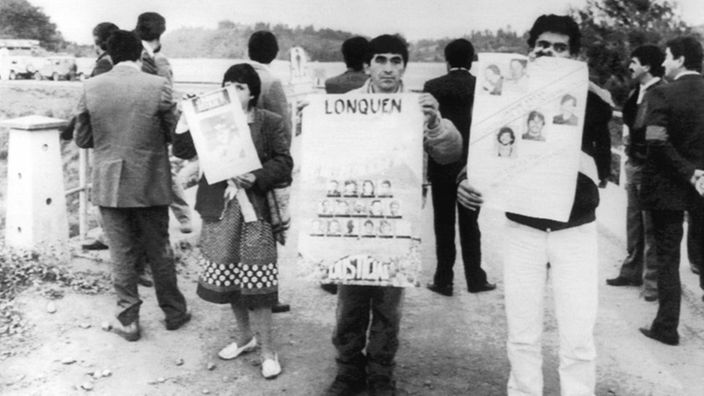 Eltern demonstrieren mit Plakaten vor der Siedlung der Colonia Dignidad.