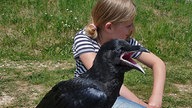 Die Tochter des Falkners in friedlicher Pose mit einem jungen Raben.