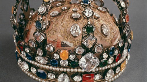 Eine üppige Goldkrone, mit großen bunten Edelsteinen besetzt. Sie gehörte einst Ludwig XV. und befindet sich heute im Louvre in Paris.